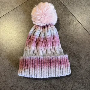 Texture de maille détaillée et pompon rose sur un bonnet d'hiver épais à dégradé