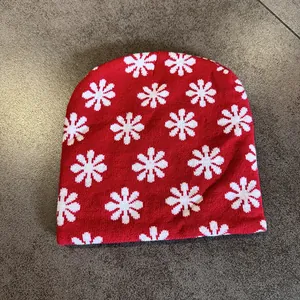 Detailed knit texture of a red and white floral patterned beanie for winter warmth