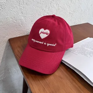Close-up of red cotton baseball cap with heart embroidery and Every Moment Is Special text
