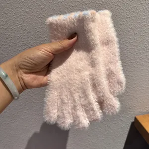 Dettaglio della trama dei morbidi guanti invernali in peluche rosa con polsini a righe