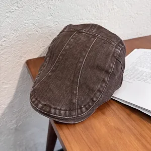Close-up of vintage dark brown beret with contrast white stitching on a wooden table