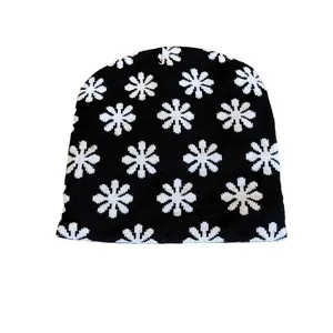 Contrast floral knit beanie with white flower patterns on black textured fabric