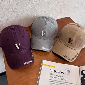 Classic embroidered baseball caps in purple, gray, and khaki on a wooden background