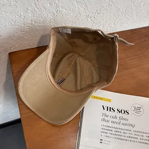 Detail view of khaki baseball cap interior with cotton sweatband and metal buckle