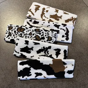 Flat lay detail of five knitted headbands featuring cow and leopard animal prints