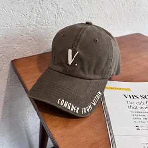 Detailed view of V letter embroidery and Conquer text on vintage cotton baseball cap