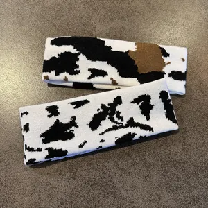 Detail of cow print knitted sports headbands in black, white, and brown yarn textures