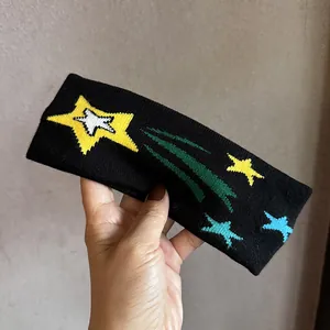 Detail eines schwarzen Strick-Stirnbands mit bunten Sternen und Kometen-Design