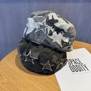 Vintage camouflage newsboy hats with embroidered white stars on a wood tabletop