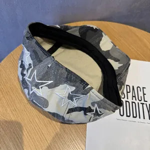 Detail of camouflage beret with white star embroidery on a rustic wooden table