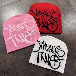 Dettaglio dei berretti Minus Two in rosa, rosso e bianco con logo graffiti nero