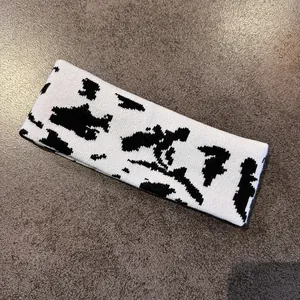 Detail of knitted cow print pattern on a white elastic headband for outdoor sports