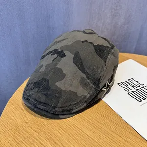 Detail view of vintage camouflage flat cap with star embroidery on a wooden table