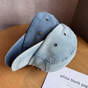 Fashionable denim baseball caps in dark and light blue wash on a rustic wood table