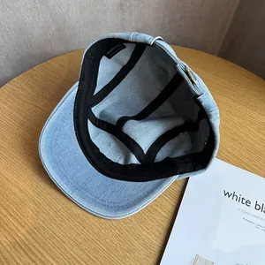 Detail of denim baseball cap interior featuring black sweatband and 100% cotton label