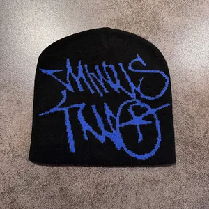 Dettaglio del jacquard graffiti blu Minus Two su un berretto nero streetwear