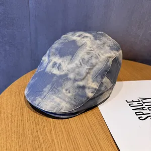 Detailed top view of blue tie-dye newsboy hat on a wooden table with soft lighting