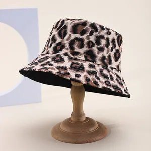 Detail of leopard print bucket hat on a wooden stand with a soft beige background