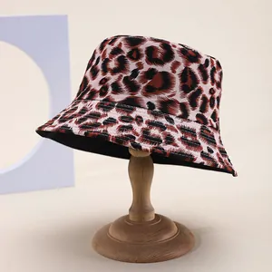 Detail shot of leopard print bucket hat on wooden stand with cotton texture