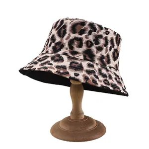 Classic leopard print bucket hat with reversible black inner layer on a wooden stand
