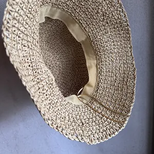 Détail d'un chapeau de paille tissé à la main avec bandeau intérieur et cordon réglable