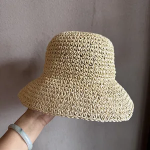 Détail d'un chapeau de paille tissé à la main montrant la texture aérée beige naturel