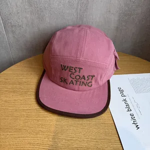 Detail of pink cotton canvas camp hat featuring green West Coast Skating embroidery