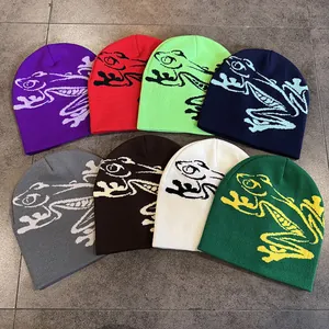 Vista piatta di berretti in maglia colorati con disegni jacquard a rana in otto tonalità