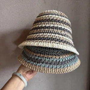 Détail de chapeaux cloches en maille ajourée tissés à la main avec motifs à rayures colorées d'été