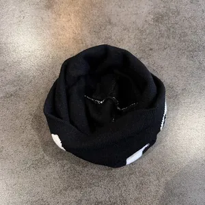 Scaldacollo invernale in maglia nera con motivi jacquard bianchi per protezione dal freddo