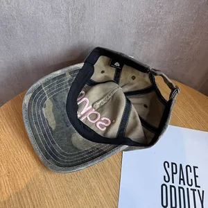 Detailed macro view of the camouflage baseball cap interior with pink embroidery