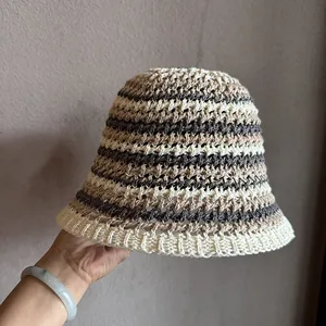 Détail du chapeau cloche au crochet à rayures avec texture de tricot beige et gris