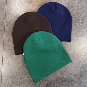 Berretti in maglia in blu, marrone e verde scuro con motivo a pois su piastrelle grigie