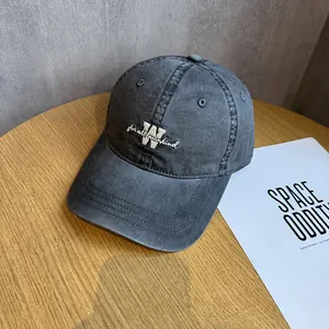 Detailed macro view of embroidered letter W on vintage washed charcoal baseball cap