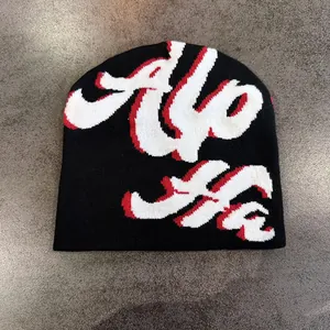Dettaglio del berretto in maglia nera con scritta Hello 3D e sfumature rosse vivaci