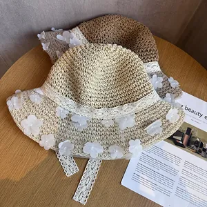 Détail de chapeaux de paille avec rubans en dentelle et fleurs 3D sur bois naturel