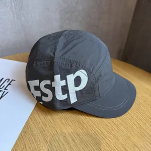 Détail d'une casquette camper grise à cinq panneaux avec imprimé fstp sur bois