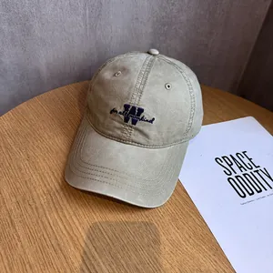Detail of embroidered navy letter W on khaki washed cotton vintage baseball cap