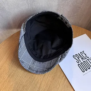 Détail du béret à carreaux montrant le tissu noir et blanc et la sangle intérieure réglable