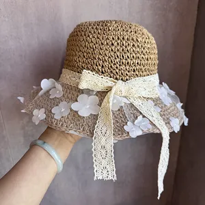 Détail du chapeau de paille avec fleurs en dentelle et élégant voile en résille