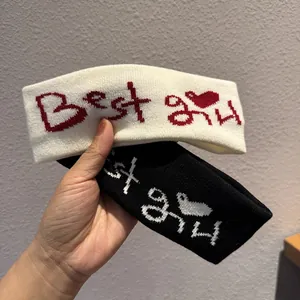 Detail of knitted elastic headband featuring Best girl embroidery and heart pattern