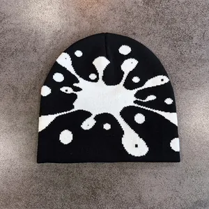 Dettaglio del berretto in maglia jacquard bianco e nero con motivi in stile street