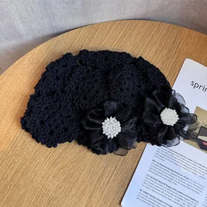 Détail du bonnet au crochet noir avec fleurs en maille faites main et perles