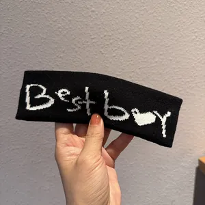 Dettaglio della trama a maglia della fascia nera con motivo jacquard Best Boy bianco