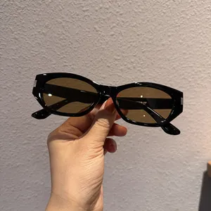 Detail of vintage black oval sunglasses featuring silver metal accents and brown lenses