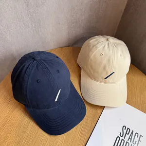 Detailaufnahme der dunkelblauen und beigen Baumwoll-Baseballkappen mit minimalistischer Stickerei