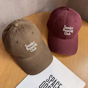 Close-up of retro cotton baseball caps with Sunday Running Club embroidery detail