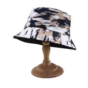Tie-dye reversible sun bucket hat for women on wooden stand for outdoor travel