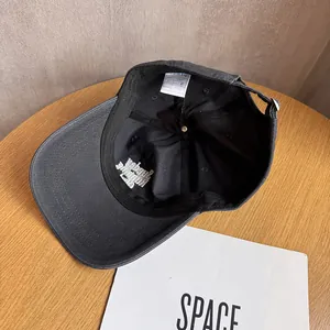 Detail of adjustable metal buckle and inner size label on charcoal cotton baseball cap