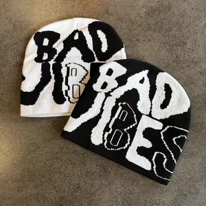 Knitted beanie with Bad Vibes graffiti lettering in black and white streetwear style